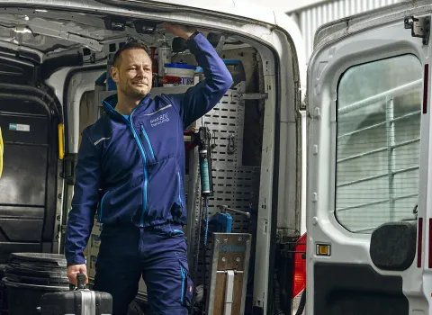 Kundendienst-Arbeiter SHK steht startbereit im Firmenwagen.