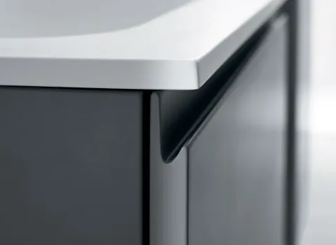 Detailansicht eines Stocco Badmöbels mit integrierter Griffleiste, matter Front und weißer Waschtischplatte.