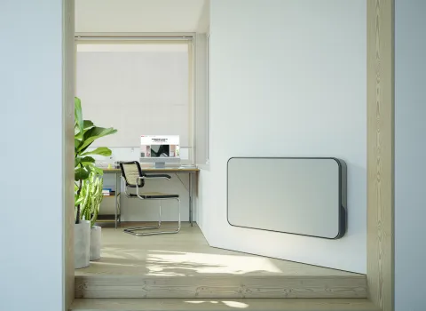 Horizontaler weißer Designheizkörper Relax Hybrid im modernen Homeoffice.