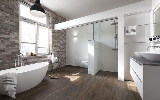 Badezimmer mit Backsteinwand und weißer Ausstattung